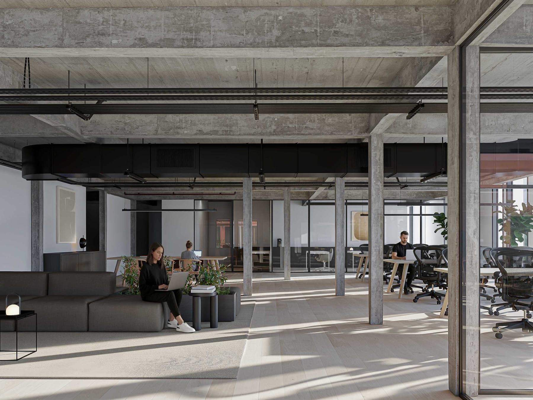 Planta libre de oficina con columnas de hormigón, piso de madera clara y luz natural