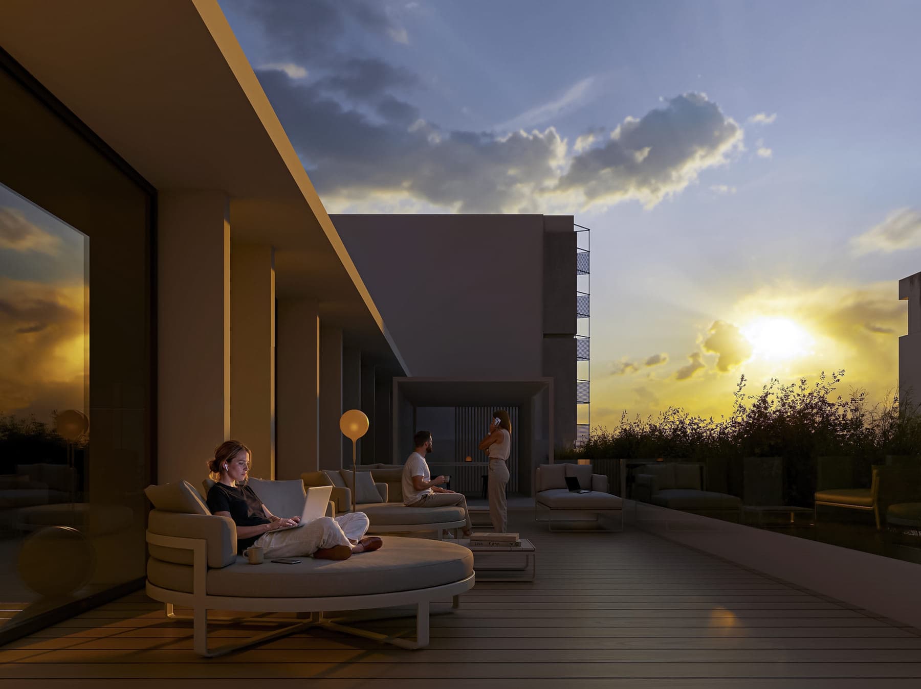 Rooftop con deck de madera, sillones y personas trabajando al atardecer